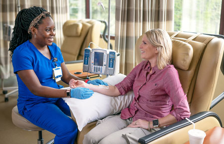 A provider comforts a patient in infusion therapy 