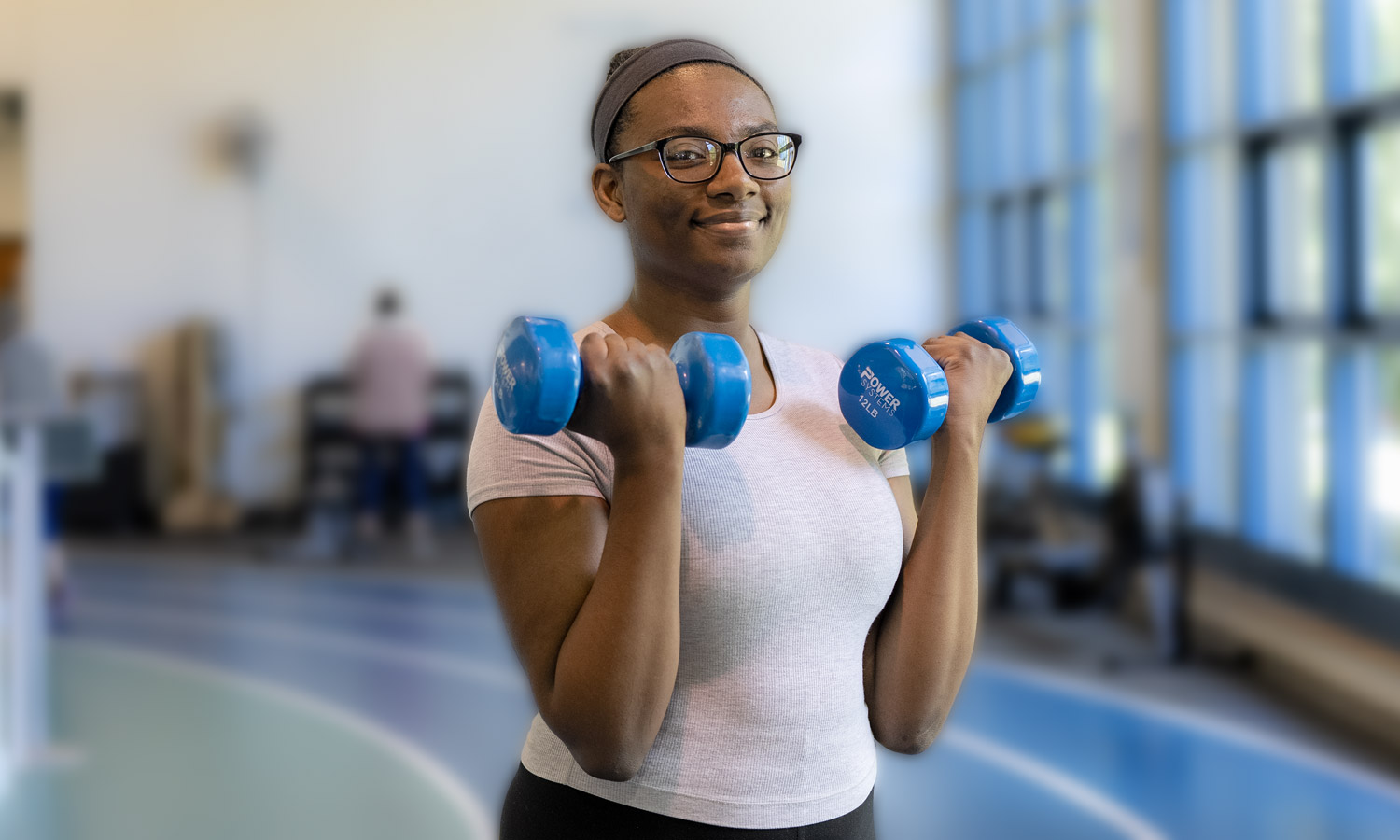 A woman lifts a set of dumbbells