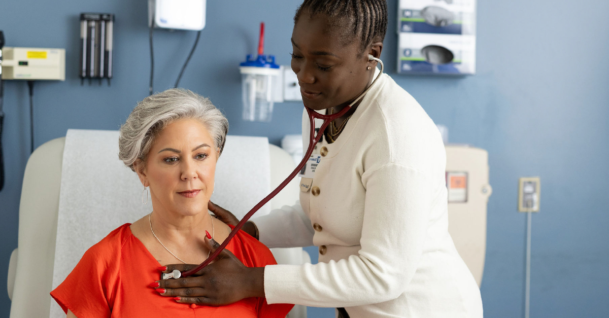Doctor listening to heart of patient in office