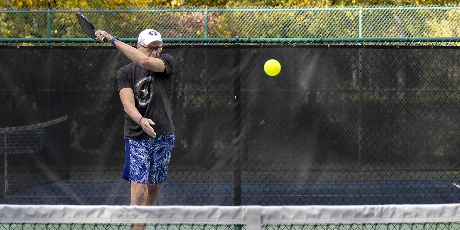Ralph practices his pickleball serve