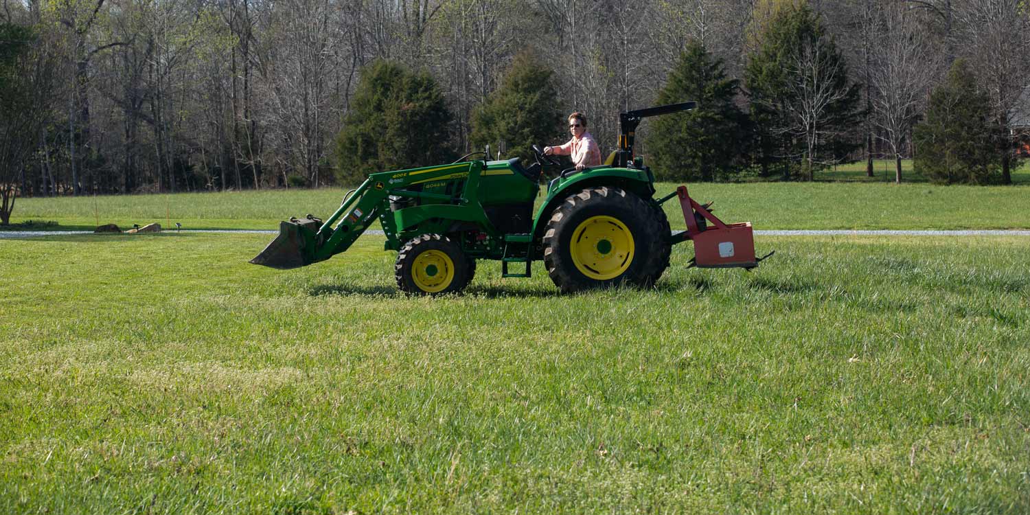 Kim Callemyn rides a tractor on her property
