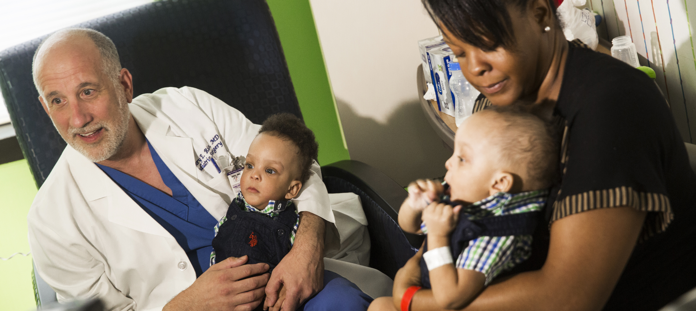 A week later, the twins are healthy enough to leave the hospital. Dr. Henry Rice, left, holds Josiah while mom Vanessa Covington cradles Aryan.