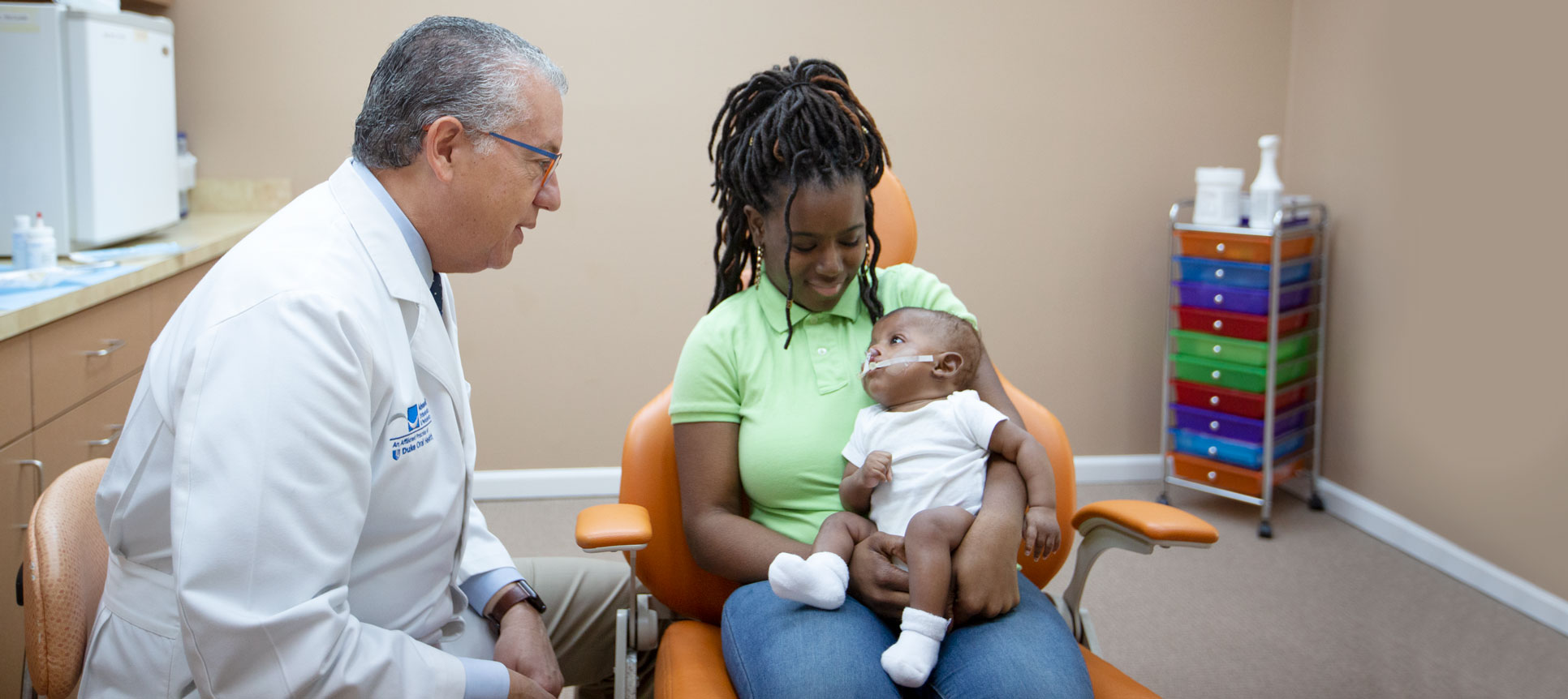 Pedro Santiago meets with a mother and her child, who is receiving treatment with the NAM device.