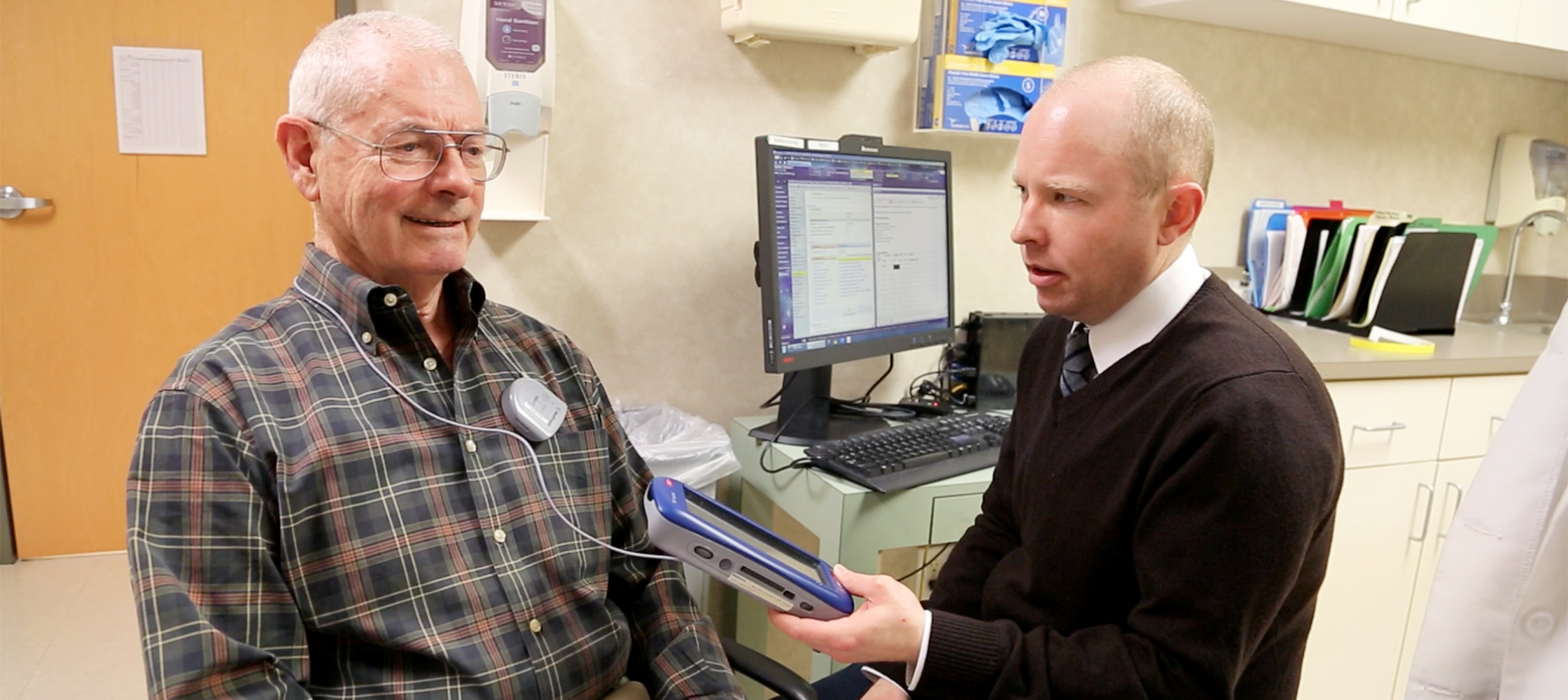 Duke neurologist Patrick Hickey, DO, sets the stimulator settings following Galvin's surgery.