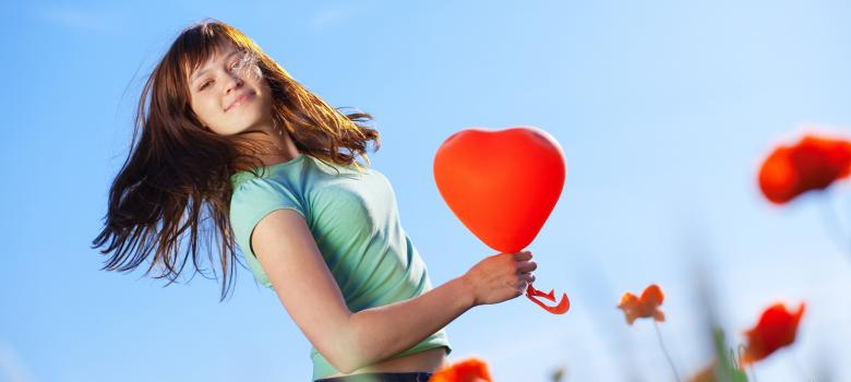 Una mujer sosteniendo un globo con forma de corazón