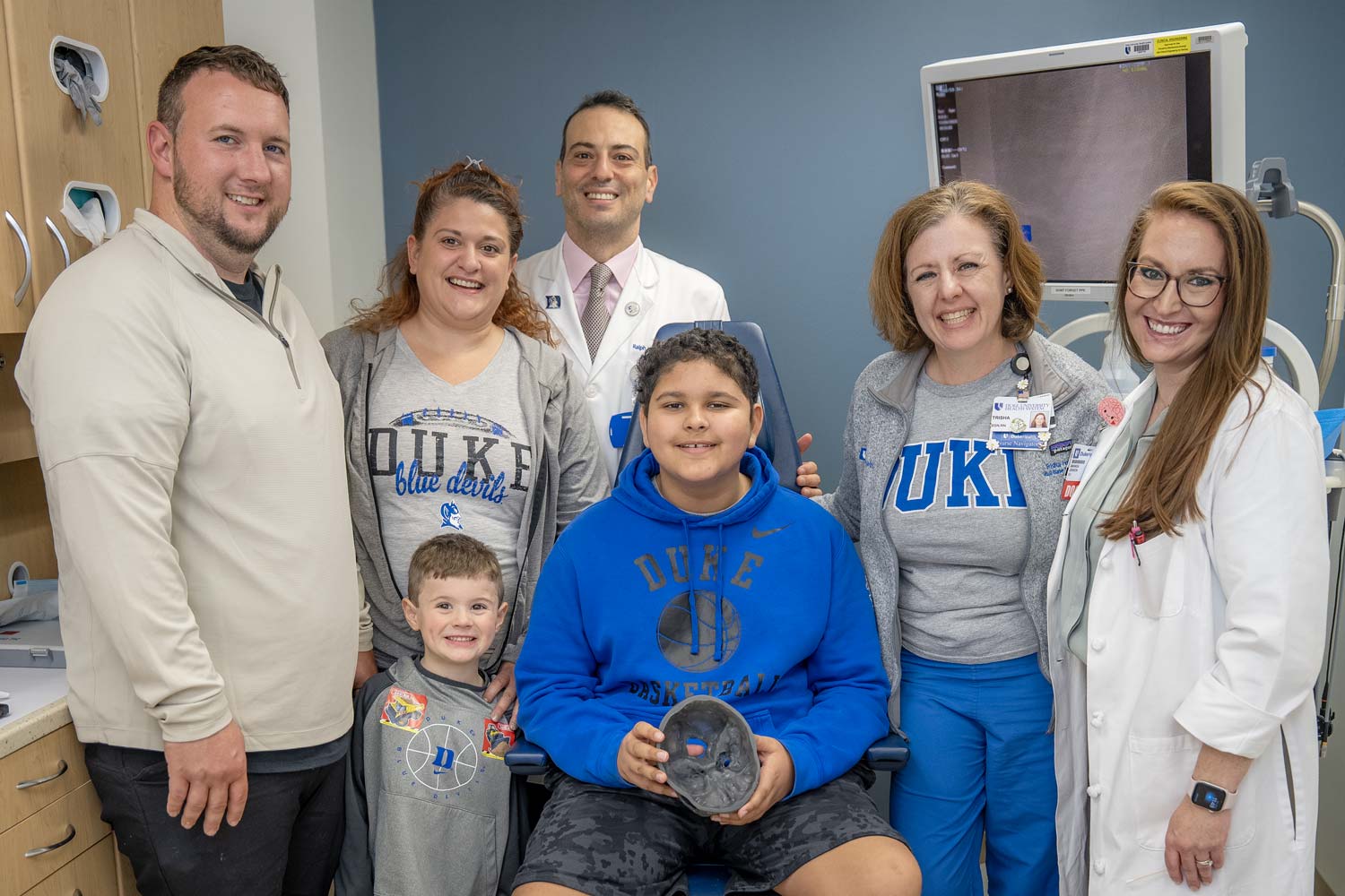 Brayden smiles with his family and part of his Duke Health care team.