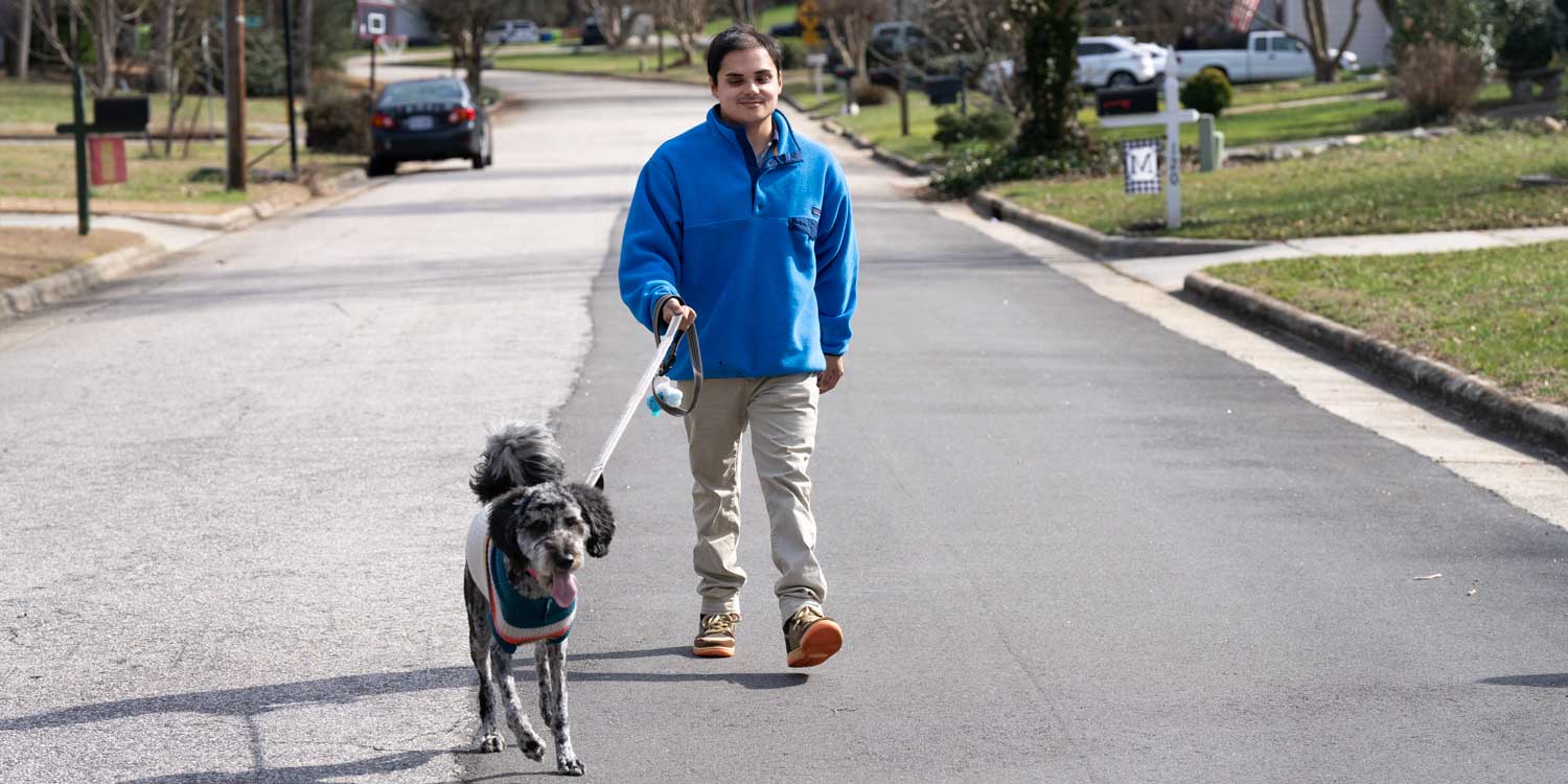 Tyler walks his dog down the street