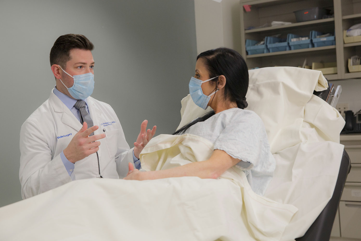 A physician talks to a patient in an operating room 
