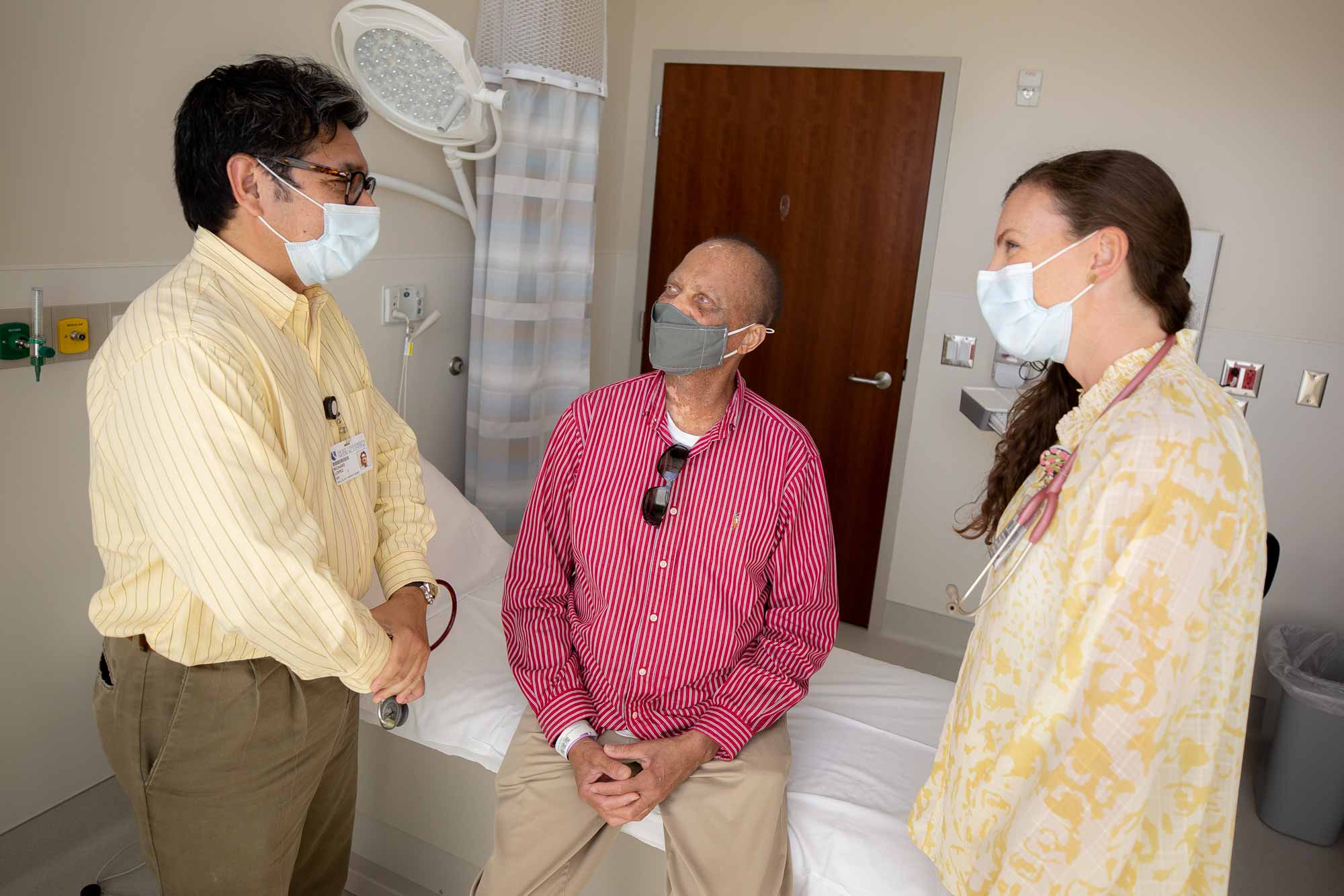 Two medical providers talk to a patient