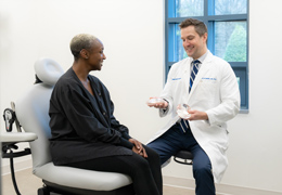 A doctor shows a patient breast implant options