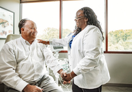A provider holds a patient's hand