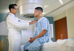 A doctor helps a patient before a scan