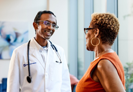 A doctor speaks with a patient in a lobby