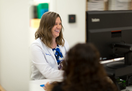 A woman helps a customer at a front desk