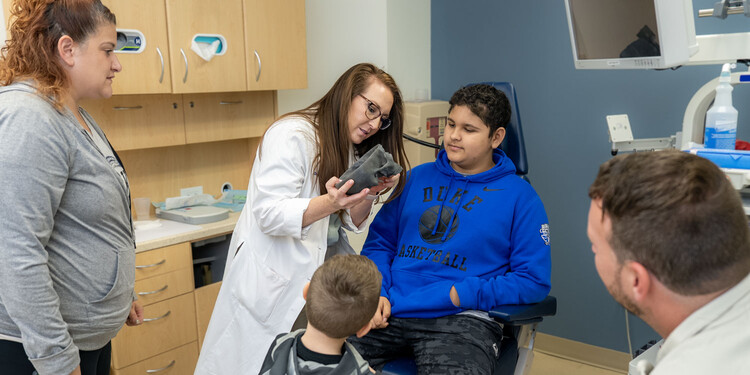 A doctor shows Brayden and his family a 3D-printed skull