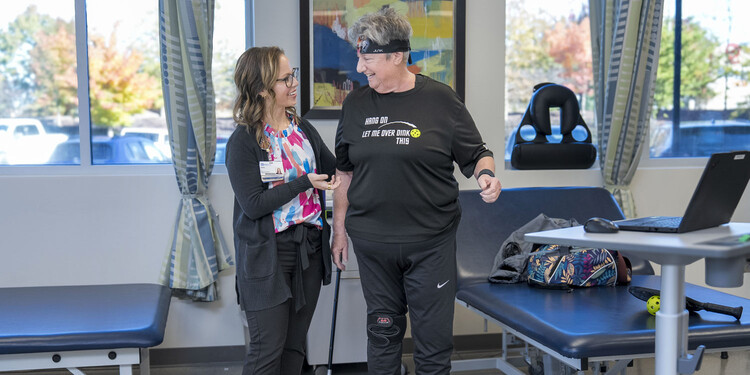 Physical therapist Katie Hester helps support a patient during a standing exercise.