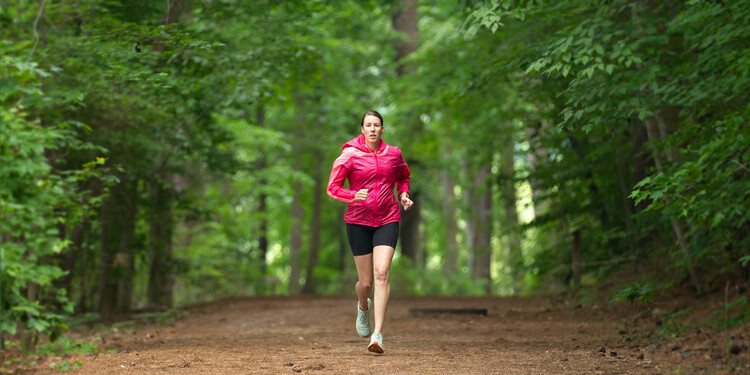 Kristina Vegh runs on a path in the woods