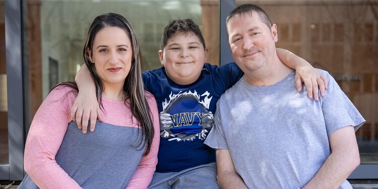 Arielle, Garin, and Nick Lege lean against an outside wall with windows