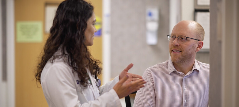Two doctors talk together in a clinic hallway
