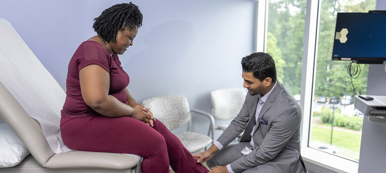 Sathish Mohan, MD, examina las piernas de paciente.
