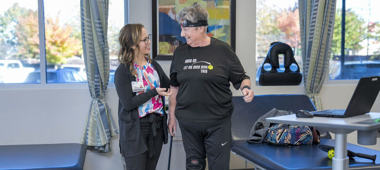 Physical therapist Katie Hester helps support a patient during a standing exercise.