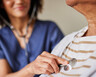 A physician listens to a patient's heart