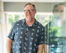 Brad Dugai leans against the glass wall of a building