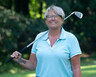 Denise Schroeder poses on a golf course with her club over her shoulder
