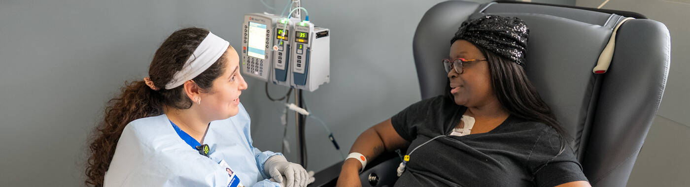 A nurse speaks with a patient during their infusion