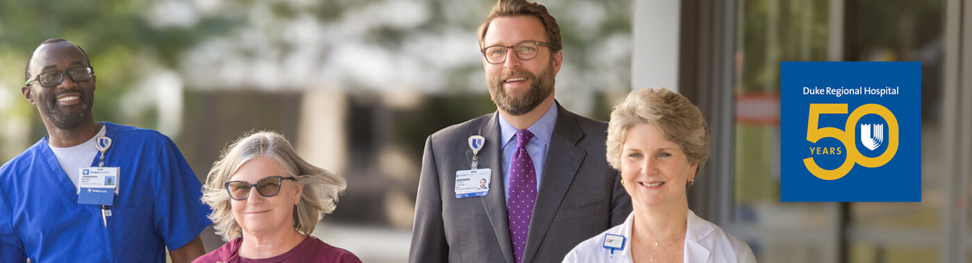Four team members walk together outside. A logo for Duke Regional Hospital's 50th anniversary is overlayed on the right side of the image.