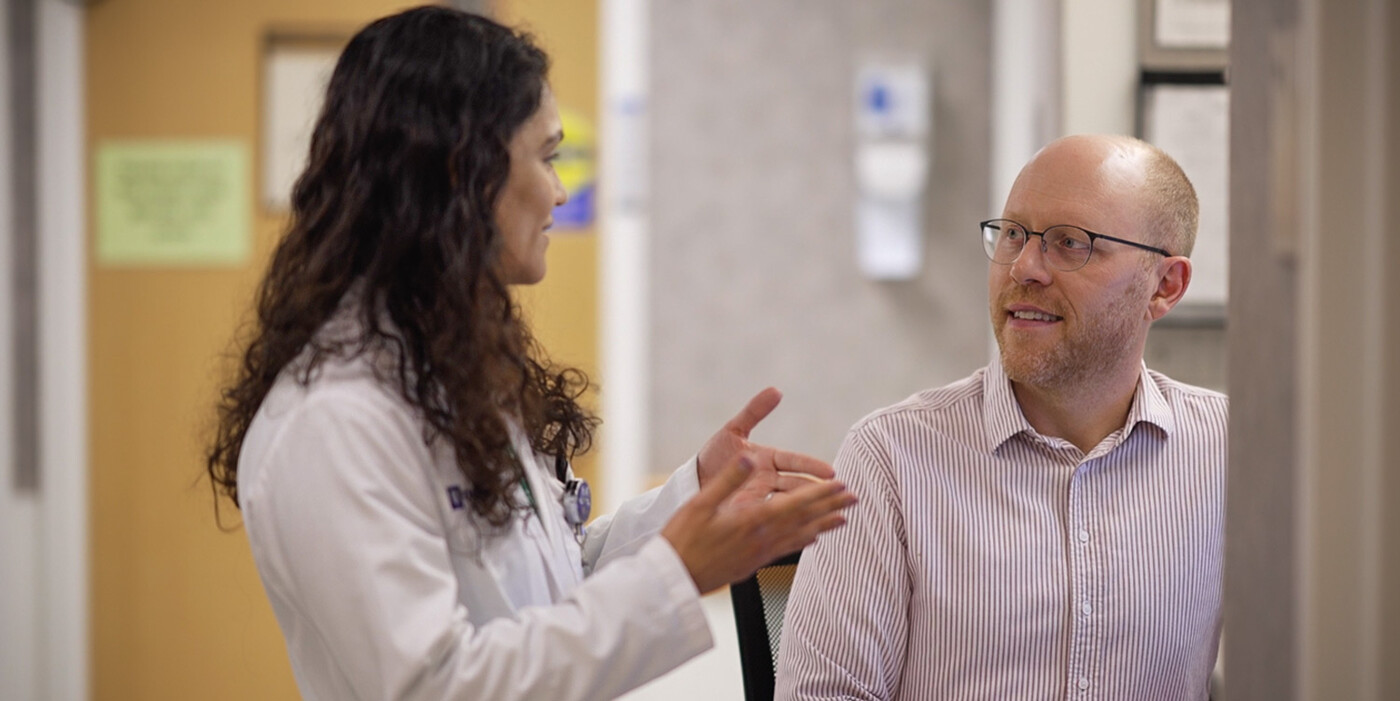 Two doctors talk together in a clinic hallway