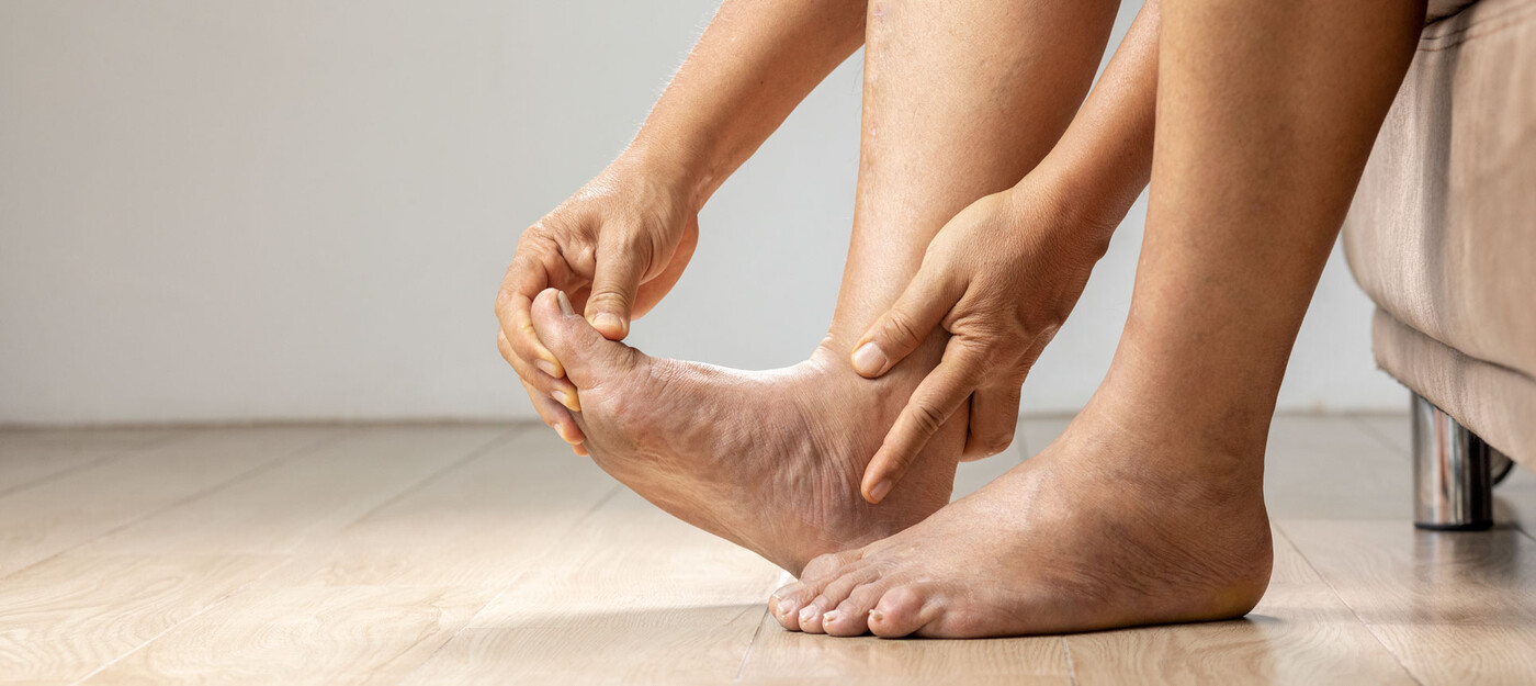 A person holds their ankle and stretches their foot