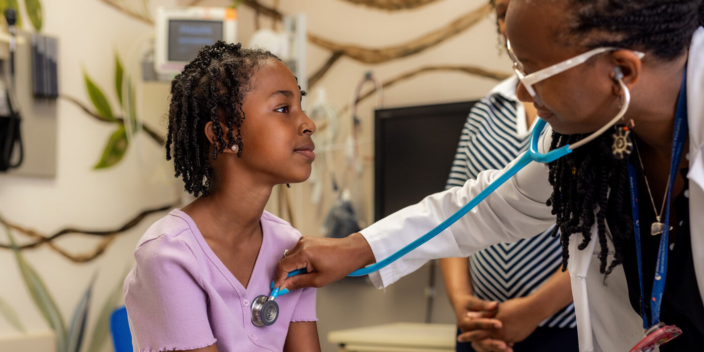 A doctor listens to a pediatric patient's heart