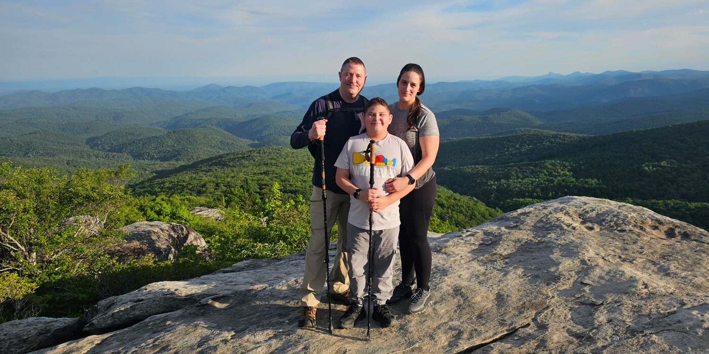 Nick, Garin y Arielle Lege están juntos en la cima de una montaña