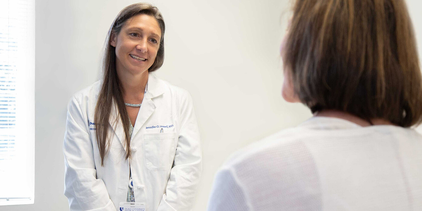 A doctor speaks with a patient in a clinic room