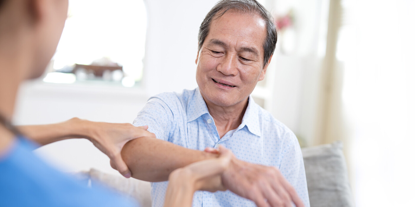 A physician holds a patients arm during an exam