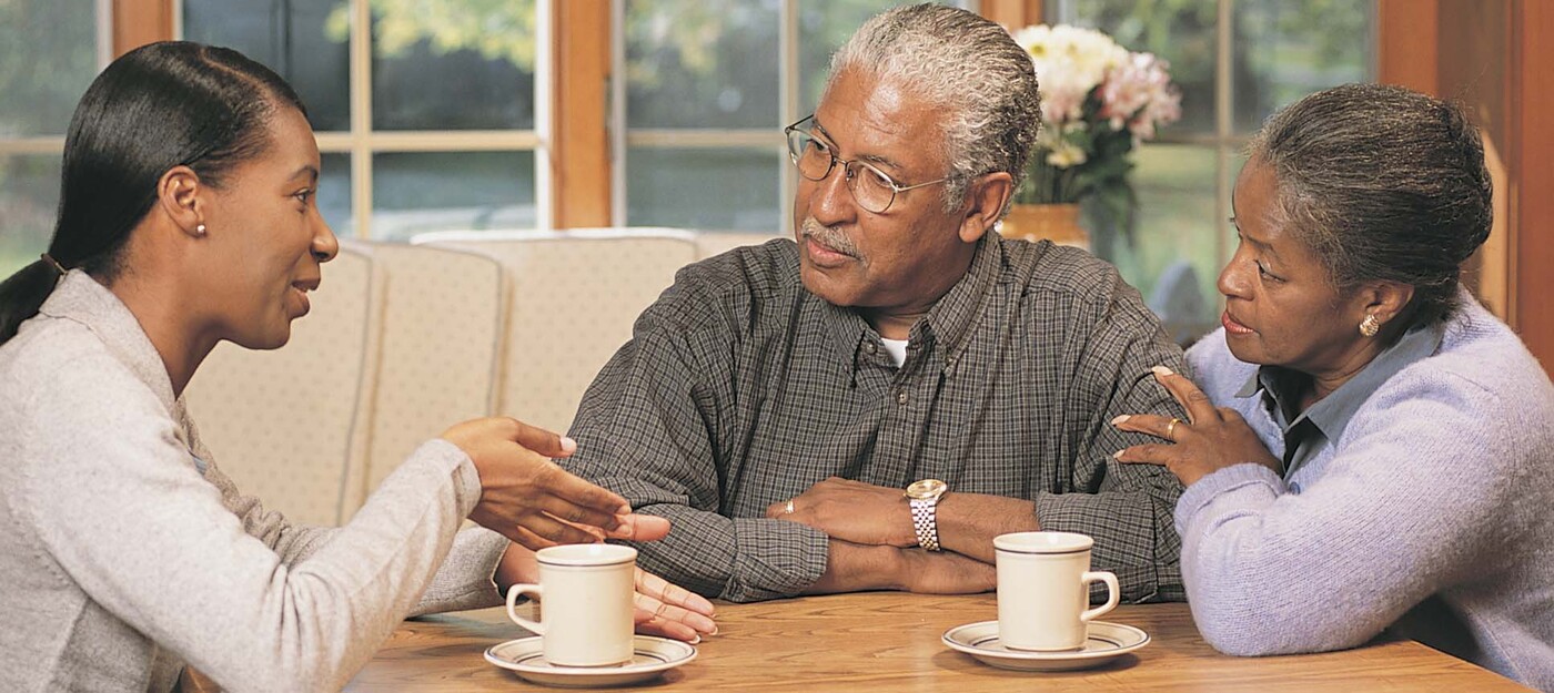 Young and old people having a discussion over coffee.