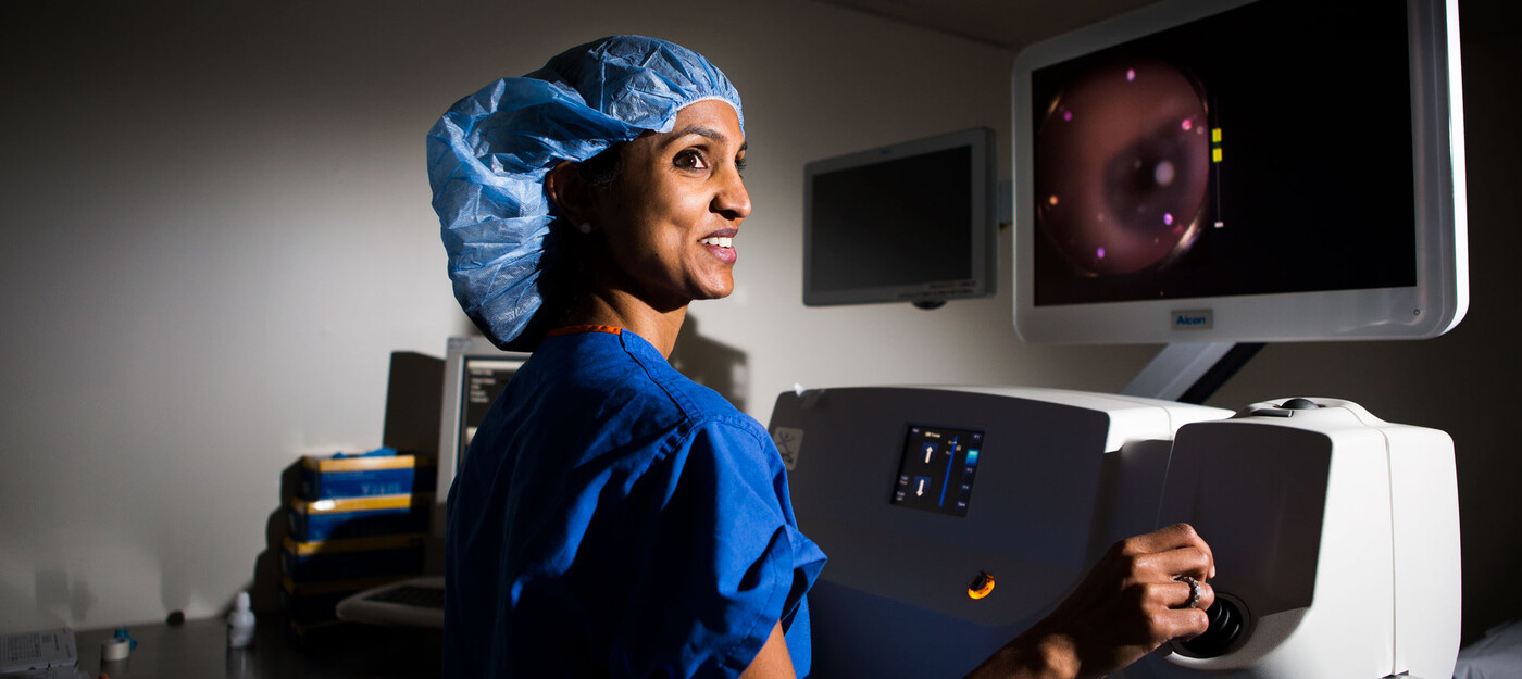 Anupama B. Horne, MD, stands with the laser used in cataract surgery