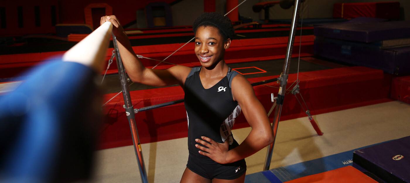 A gymnast poses at the gym