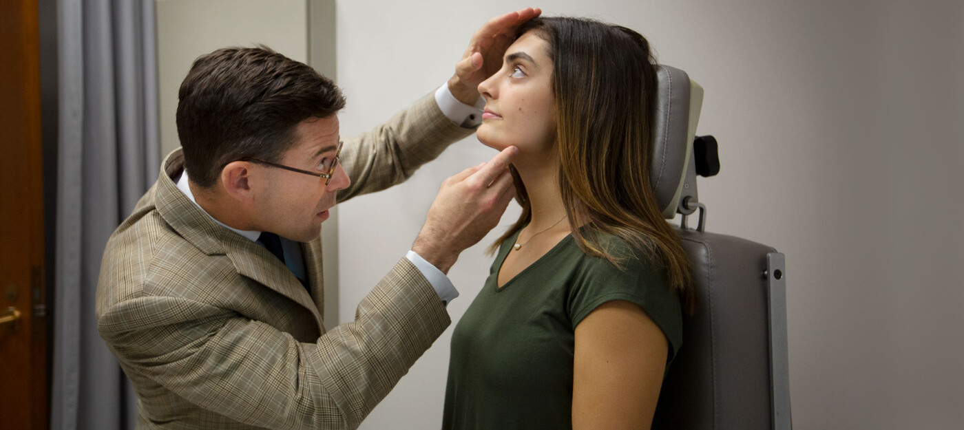 A doctor looks at a patient's nose