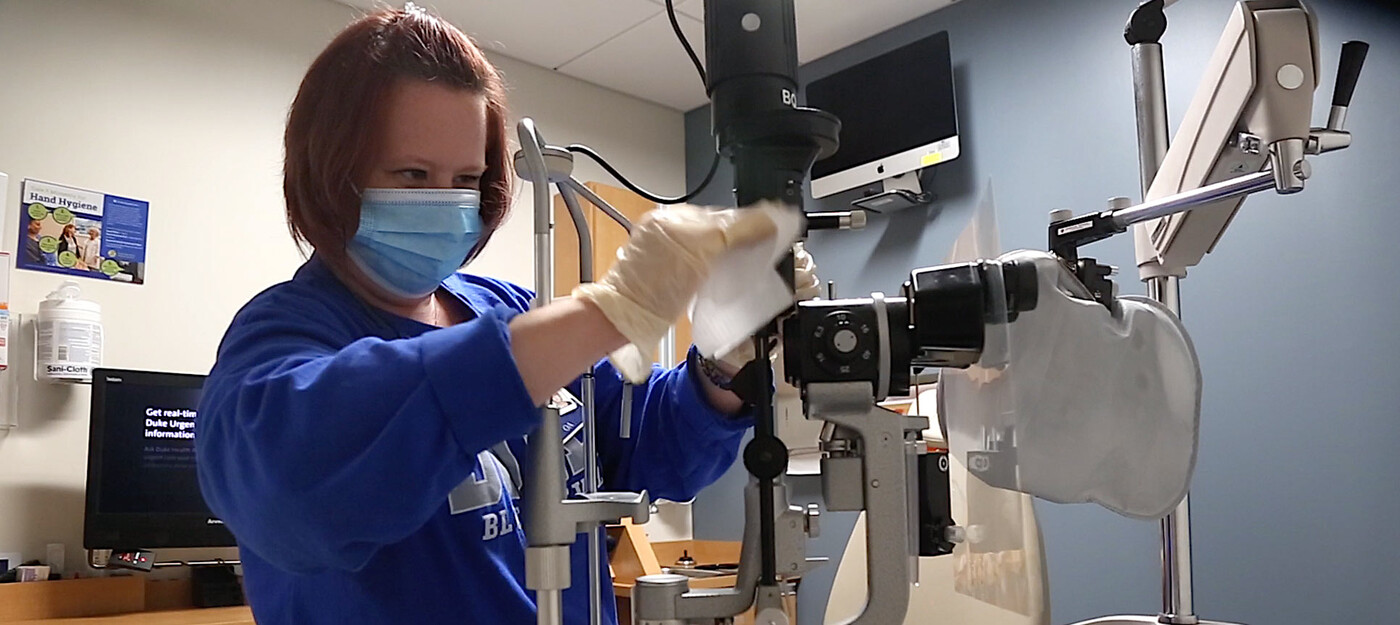 An employee cleans a slit lamp