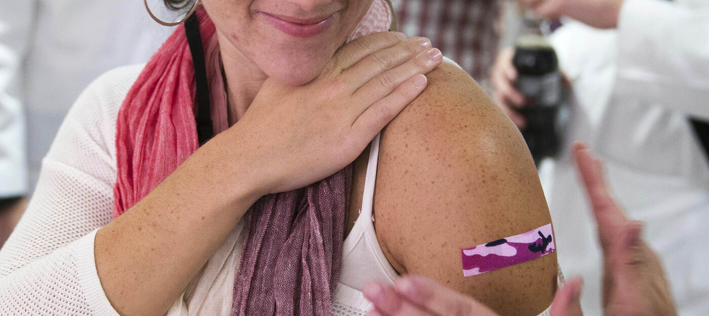 Woman getting bandaid placed after flu vaccination