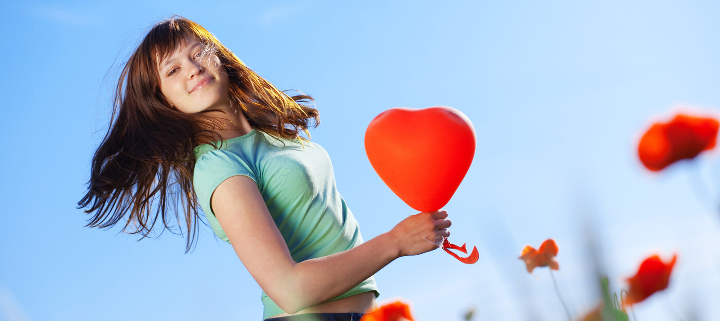Woman holding heart-shaped ballon