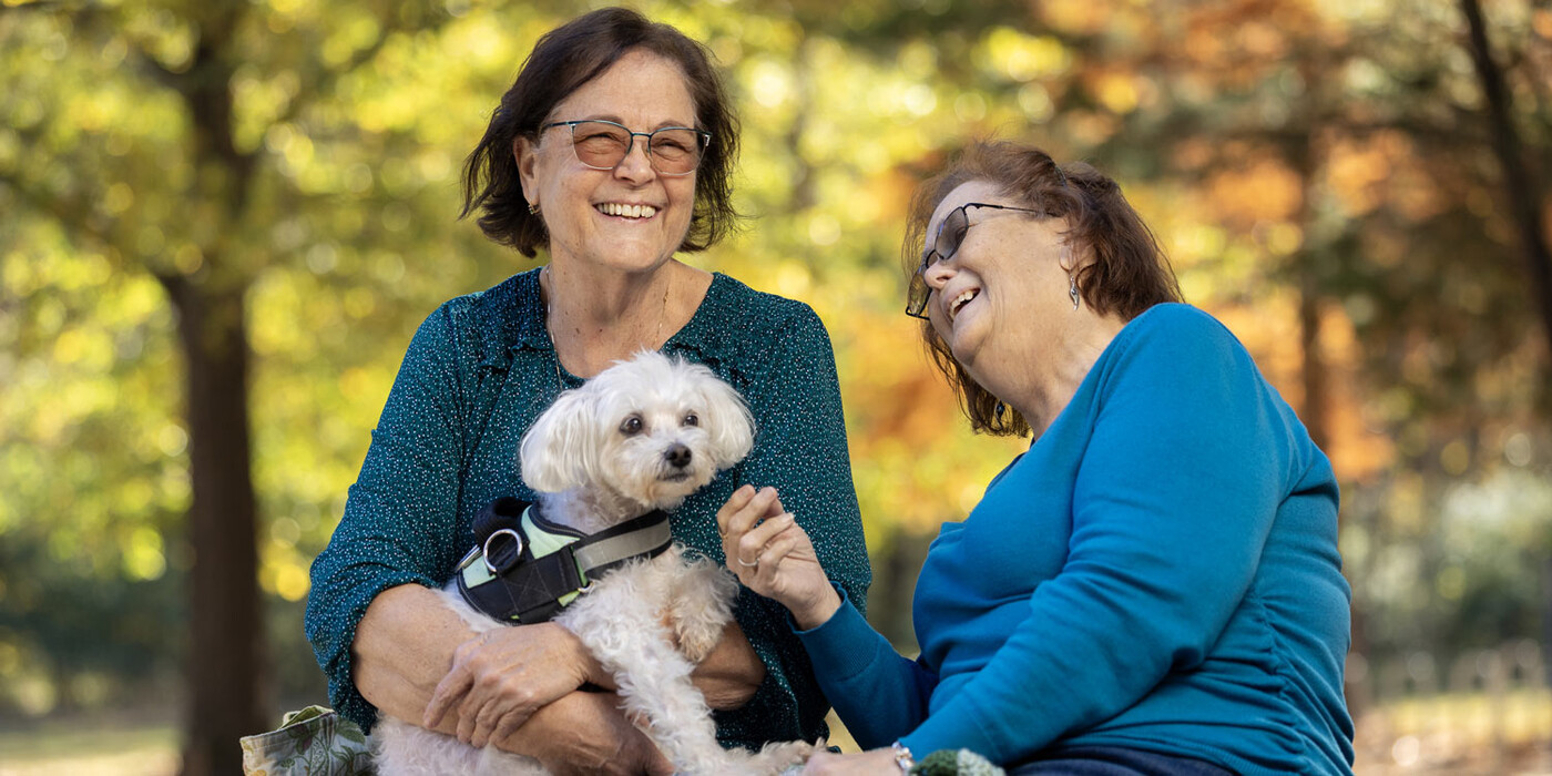 Yvette Crawley shares a laugh with her sister Melodie Rochester while giving treats to Crawley’s dog Triela in Cary, NC.