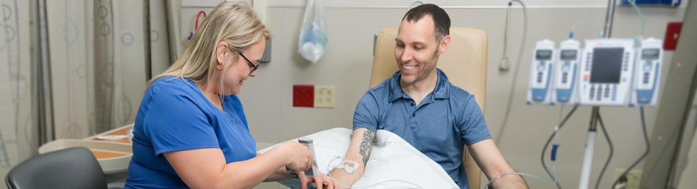 A nurse connects a patient to an infusion pump