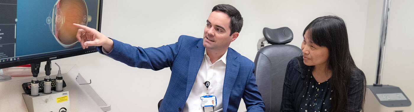 A doctor shows a patient an image of an eye
