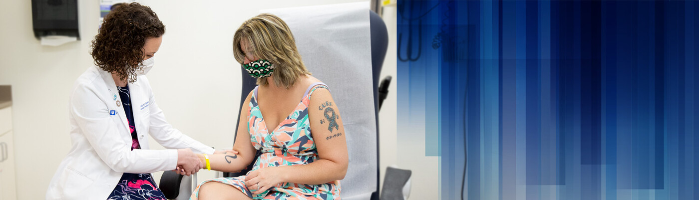 A provider feels a patient's arm muscle in clinic