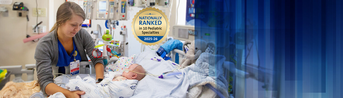 A physician checks on an infant in a hospital bed