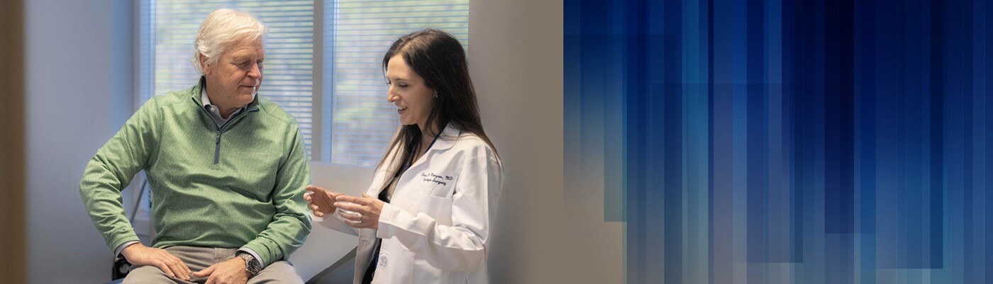 A doctor speaks with a patient in a clinic room