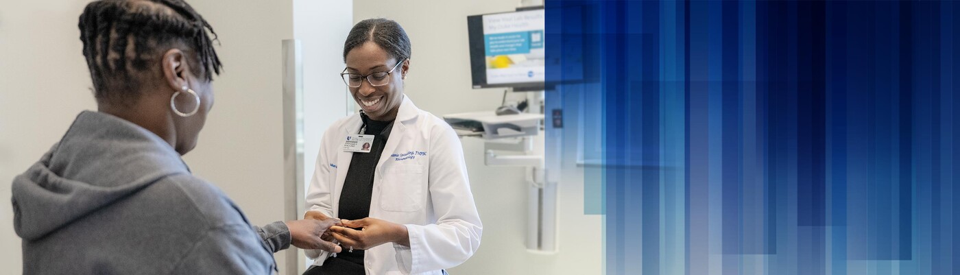 A doctor examines a patient's hand in clinic